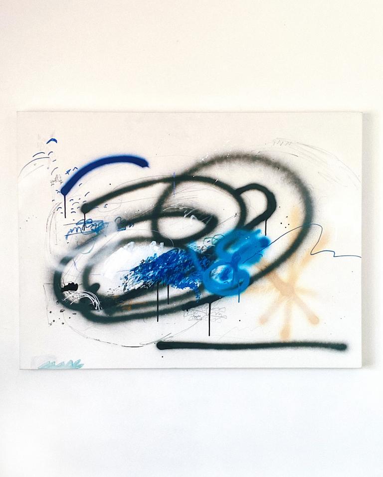 Artwork hung on a wall, with black, blue and white hues.