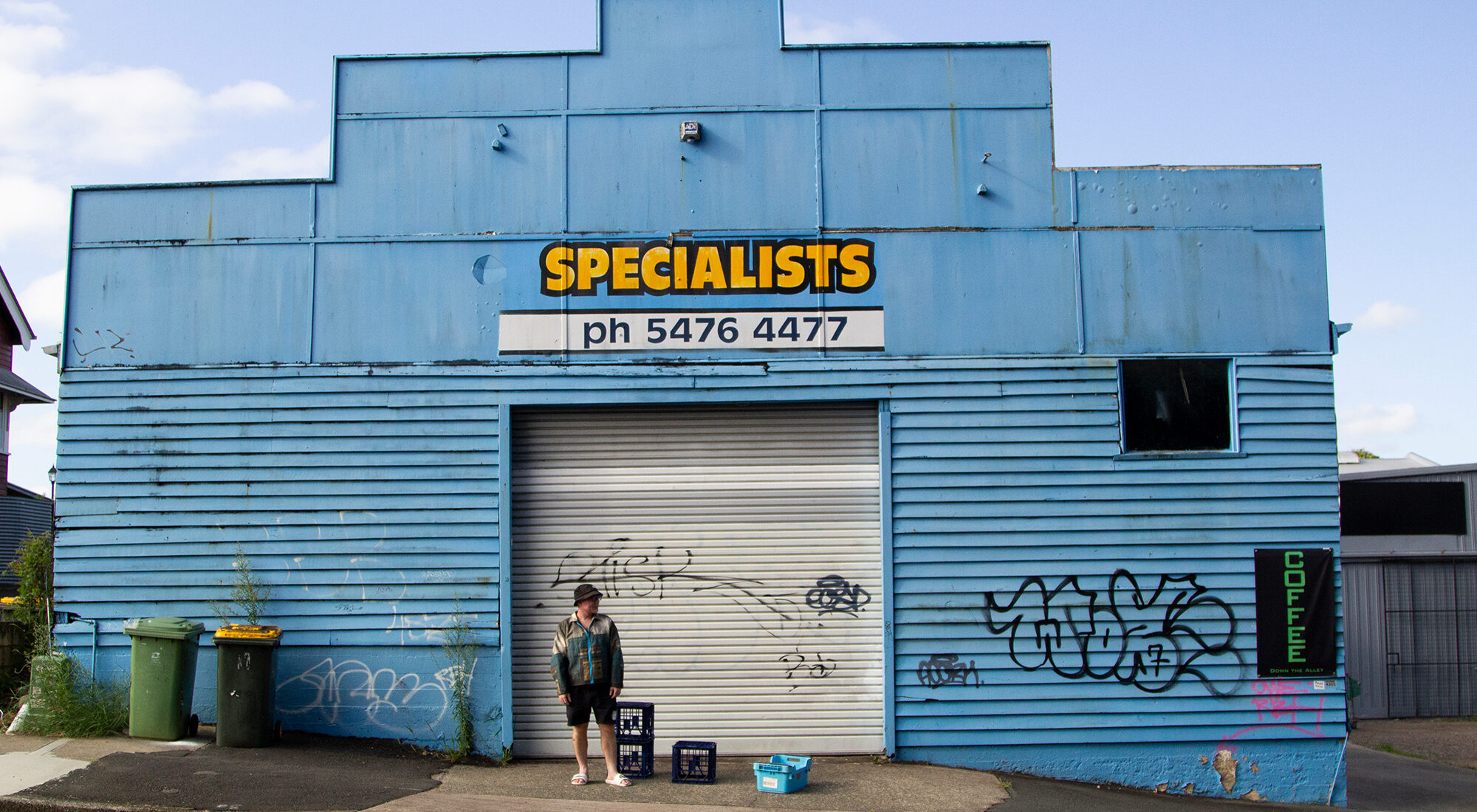 A person stood in front of a blue factory.